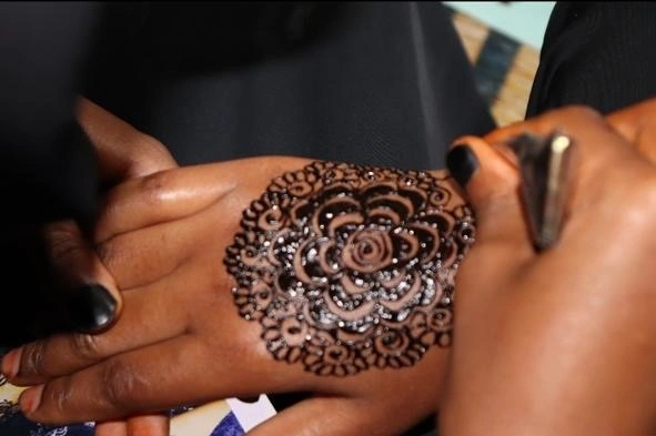 A hand decorated with a detailed henna design